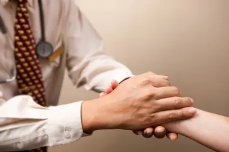 Doctor grasping patient's hand
