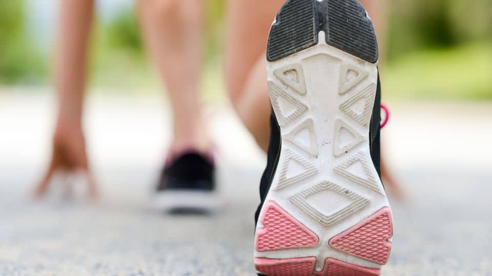 Woman feet running on road closeup on shoe