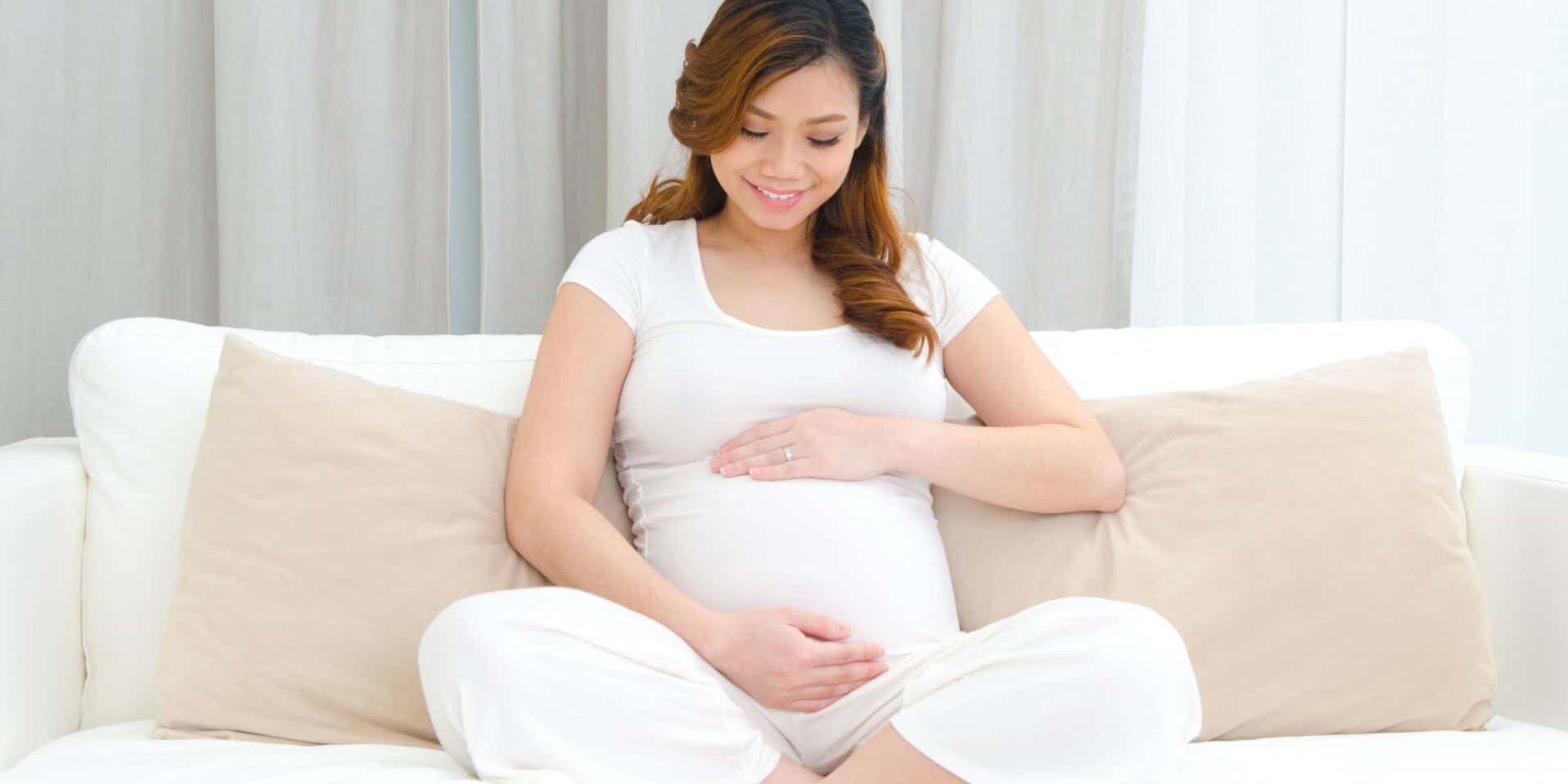 Raffles Womens Centre - pregnant lady looking fondly at her baby bump